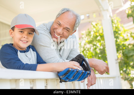 Großvater und Enkel mit Baseballhandschuh auf Veranda Stockfoto