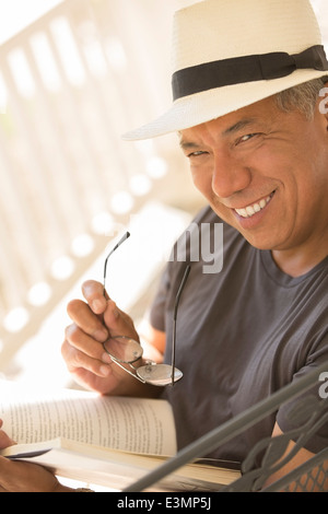 Porträt von lächelnden Mann liest Buch Stockfoto