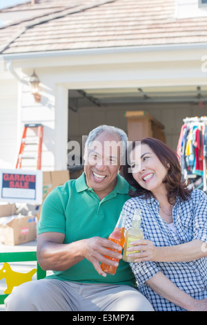 Porträt des glücklichen Paares Toasten Soda-Flaschen auf Flohmarkt Stockfoto