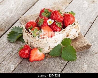 Frische Erdbeeren im Korb auf Holztisch Hintergrund Stockfoto