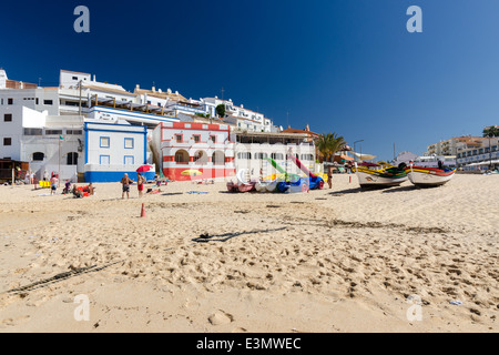 Urlauber am Sandstrand in der kleinen Küstenstadt Carvoeiro an der Algarve Stockfoto