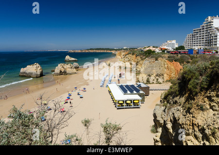 Restaurant und eine Reihe von Liegestühlen auf der großen Sandstrand von Praia da Rocha, Portimao an der Algarve Stockfoto