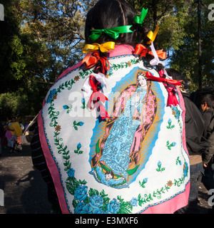 Eine Frau mit der Jungfrau von Guadalupe drapiert auf dem Rücken während der Festlichkeiten in Morelia, Michoacan, Mexiko. Stockfoto