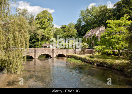 Die Brücke über den Fluss Coln & das Swan Hotel in der hübschen Cotswold Dorf Bibury, Gloucestershire, UK an einem Sommertag Stockfoto