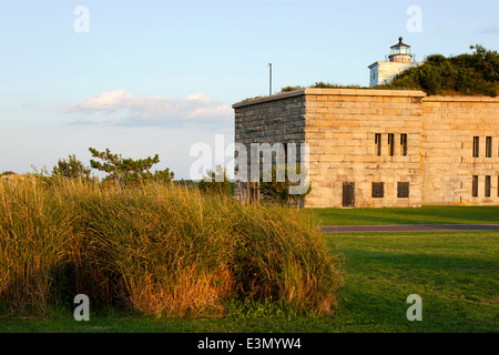 Sonne hinter Clarks Point Lighthouse, wie es auf der Spitze Fort Taber Park in New Bedford, Massachusetts sitzt. Stockfoto