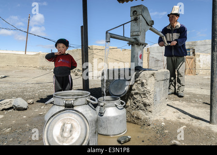 Mann und der junge sammeln von Wasser aus einem Brunnen, Karakul See, Pamir Highway, Tadschikistan Stockfoto