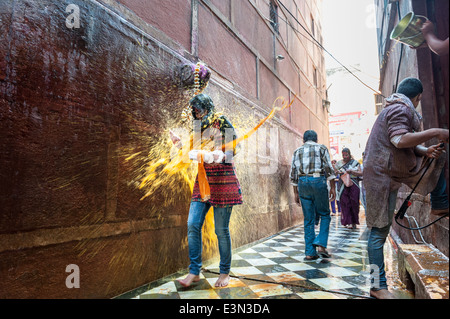 Mädchen in farbigem Wasser getränkt, während der Feierlichkeiten des Holi-fest, Vrindavan, Indien Stockfoto