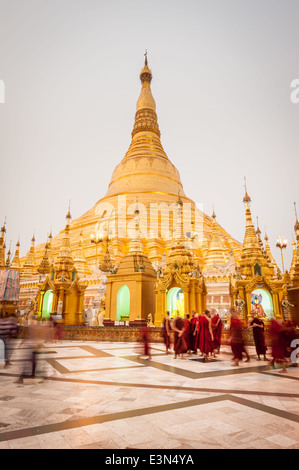 Gruppe von Mönchen vor der Shwedagon-Pagode bei Sonnenuntergang, Yangon, Myanmar, Asien Stockfoto