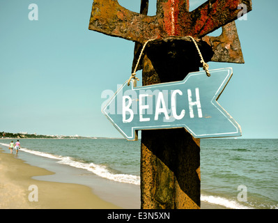 Retro-Konzept 50er 60er Film Bild Behandlung Strand Schild hängen auf rustikalen Post paar im Hintergrund Sandbänke Dorset UK Stockfoto