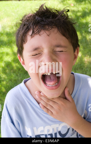 Sieben 7 Jahre alt mit strubbeligem Haar zeigt Excitedlly seine fehlende Schneidezahn Modell veröffentlicht Herr Stockfoto