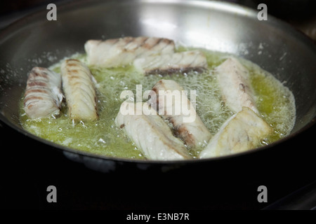 Nahaufnahme von Fisch in Pfanne braten Stockfoto