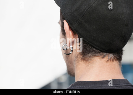 Rückansicht des jungen Mannes tragen Ohrstecker im freien Stockfoto