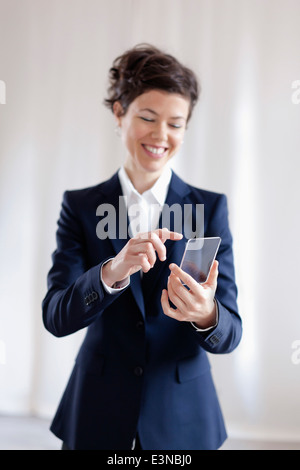 Attraktive Geschäftsfrau hält virtuelle Smartphone Stockfoto