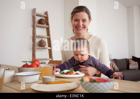 Porträt der glückliche Mutter mit Babymädchen am Tisch sitzen Stockfoto