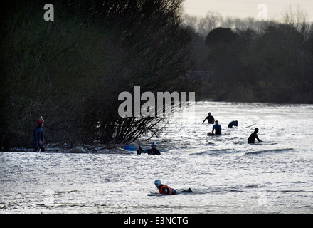 Surfer und Kanuten sind Pädagogen nach dem Reiten die Severn Bore in Minsterworth, Gloucestershire UK 2014 Stockfoto