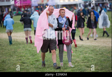 Glastonbury, Somerset, UK. 26. Juni 2014. Festivalbesucher vertuschen vor dem Regen auf dem 2014 Glastonbury Festival würdig Farm in Somerset. Europas größte Festival beginnt morgen offiziell. 26. Juni 2014. Bildnachweis: Lloyd/Alamy Live-Nachrichten Stockfoto