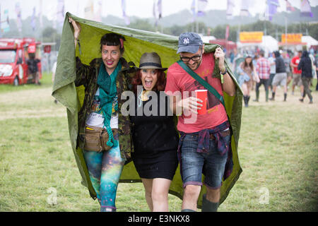 Glastonbury, Somerset, UK. 26. Juni 2014. Festivalbesucher vertuschen vor dem Regen auf dem 2014 Glastonbury Festival würdig Farm in Somerset. Europas größte Festival beginnt morgen offiziell. 26. Juni 2014. Bildnachweis: Lloyd/Alamy Live-Nachrichten Stockfoto