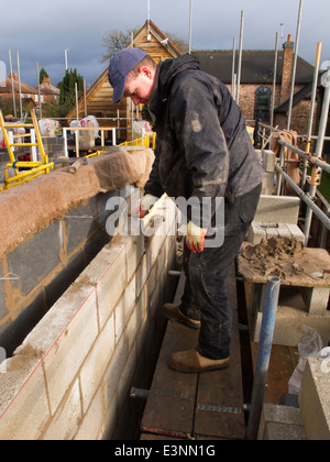 Selbstbau-Haus, Maurer Verlegung Obergeschoss Betonblock Wand von Gerüst Stockfoto