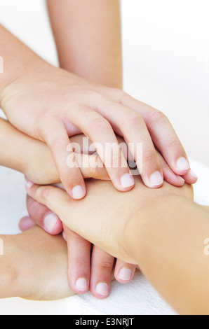 viele Hände übereinander gestapelt, in Zeichen der vertrauensvolle Freundschaft Stockfoto