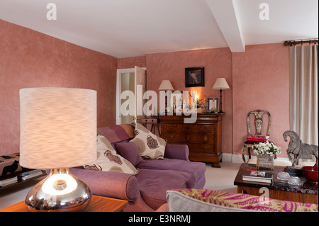 Lila Sofa gepolstert in Maya von Manuel Canovas im Wohnzimmer mit Marmor gekrönt französische Kommode mit Getränke-Fach an der Spitze Stockfoto