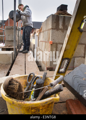 selbst Hausbau, Maurer auf Gerüsten Verlegung Obergeschoss außen Beton mischen Mörtel blockiert Stockfoto