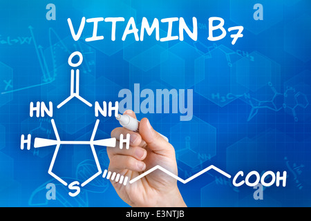 Hand mit Federzeichnung die chemische Formel von Vitamin B7 Stockfoto