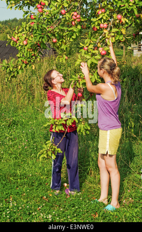 Lebensstil der ländlichen Sommer 2013. Bewohner des Dorfes - Mutter und Tochter in der Nähe von einem Apfelbaum. Stockfoto