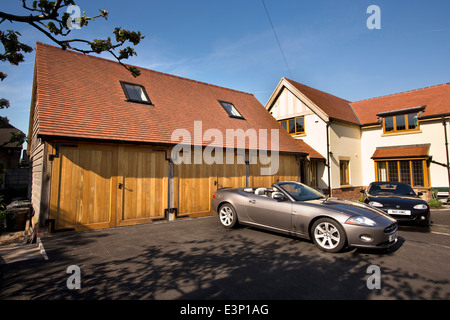 Hausbau, neue selbst gebautes Haus mit Jaguar XK und Mazda mx5 Auto parkte auf Asphalt fahren neu verlegt Stockfoto