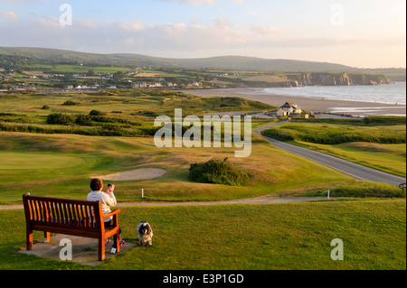 Newport Links Golf Club, Frau auf der Bank mit Blick auf Strand von Newport, Pembrokeshire, Wales, UK