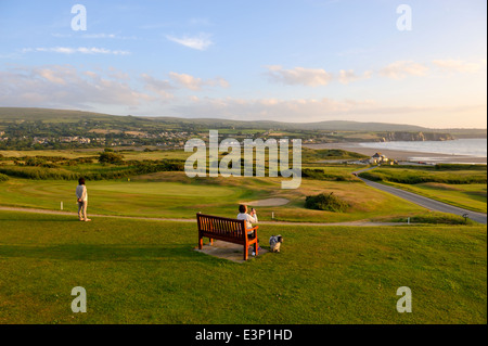 Newport Links Golf Club, Frau auf der Bank mit Blick auf Strand von Newport, Pembrokeshire, Wales, UK Stockfoto