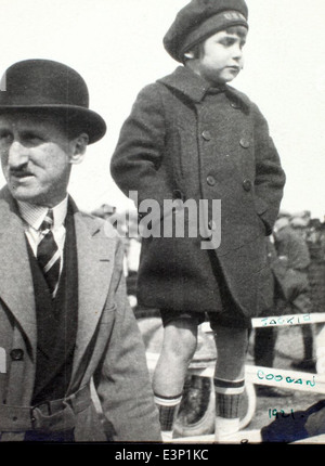 Dieses Bild aus dem AL-73B Luqueer Album zeigt Jackie Coogan, einen beliebten Kinderdarsteller aus dem Goldenen Zeitalter Hollywoods. Coogan, bekannt für seine Rolle in Charlie Chaplins *The Kid*, wurde zu einer Kultfigur im frühen Kino. Seine Verbindung zur Luftfahrt wird hier gesehen, wenn er mit einem Flugzeug posiert und seinen Hollywood-Ruhm mit der aufkeimenden Luftfahrtkultur der damaligen Zeit verschmilzt. Stockfoto