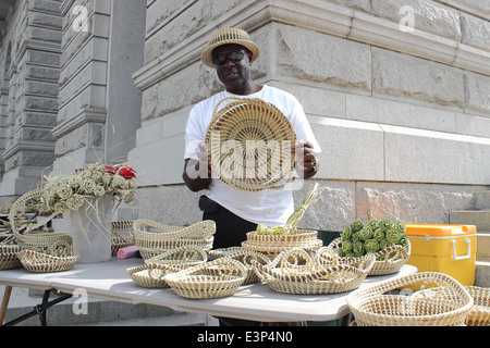 Ein Sweetgrass Korbmacher zeigt seine Kreationen auf der Meeting Street in Charleston, South Carolina, USA. Stockfoto