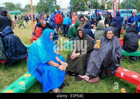 Glastonbury Festival, 26. Juni 2014: Festival Besucher sitzen in den Regenduschen. Trotz der Menschenmassen Regenguss bleiben Sie in bester Laune. Bildnachweis: Tom Corban/Alamy Live-Nachrichten Stockfoto