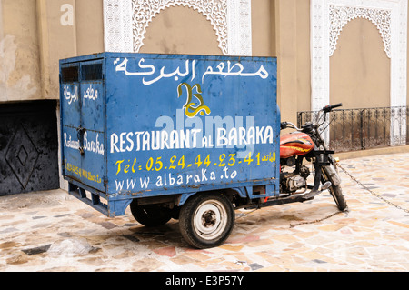 Ein Motorrad van, die zu einem Restaurant, mit handbemalten Werbung in Französisch und Arabisch, Marrakesch, Marokko. Stockfoto