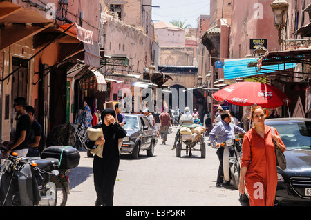 Viele Leute auf verschiedene Verkehrsträger entlang einer engen Straße in der Medina, Marrakesch, Marokko, Stockfoto