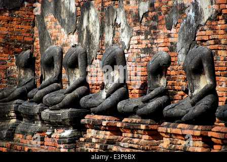 AYUTTHAYA, THAILAND: Geschwärzten Überreste aus einer Reihe von Stein sitzenden Buddhas im Jahre 1629 Wat Chai Wattanaram Stockfoto