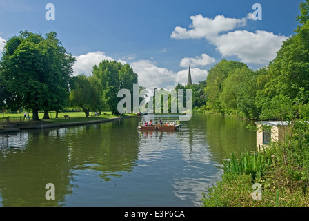 Die Kette Fähre in Betrieb über den Fluss Avon in Stratford on Avon, mit dem Turm der Kirche der Heiligen Dreifaltigkeit in der Ferne. Stockfoto