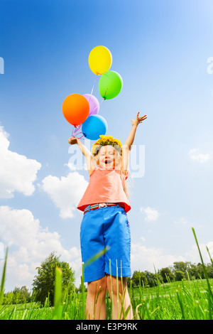 Glückliches Mädchen mit Luftballons tragen Blumen reif Stockfoto