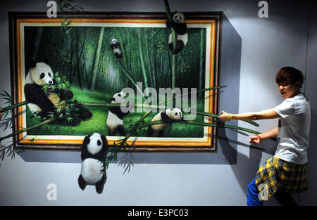 Hong Kong, China. 26. Juni 2014. Ein Besucher posiert für ein Foto mit einem 3D Bild im HK 3D Museum in Hongkong, Südchina, 26. Juni 2014. 3D Kunst Museum, das erste dieser Art in Hong Kong, wurde hier am Donnerstag vorgestellt. Bildnachweis: Lo Ping Fai/Xinhua/Alamy Live-Nachrichten Stockfoto