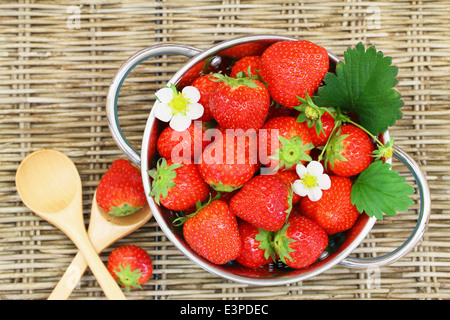 Erdbeeren in Sieb auf Wicker Oberfläche Stockfoto