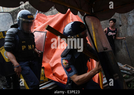 Quezon City, Philippinen. 26. Juni 2014. Polizisten geben Sie ein Zuhause während der Abriss der Baracken in Quezon City, Philippinen, 26. Juni 2014. Die lokale Regierung bestellte den Abbau von Shanties auf Wasserwegen, Überschwemmungen während der Regenzeit zu vermeiden. Bildnachweis: Rouelle Umali/Xinhua/Alamy Live-Nachrichten Stockfoto