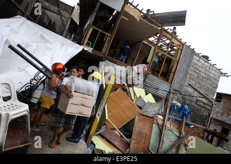 Quezon City, Philippinen. 26. Juni 2014. Ein Bewohner trägt seine Habseligkeiten wie Abriss Teammitglieder sein Haus in Quezon City, Philippinen, 26. Juni 2014 abzubauen. Die lokale Regierung bestellte den Abbau von Shanties auf Wasserwegen, Überschwemmungen während der Regenzeit zu vermeiden. Bildnachweis: Rouelle Umali/Xinhua/Alamy Live-Nachrichten Stockfoto