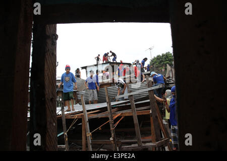 Quezon City, Philippinen. 26. Juni 2014. Abriss-Team-Mitglieder bauen Häuser beim Abriss der Baracken in Quezon City, Philippinen, 26. Juni 2014. Die lokale Regierung bestellte den Abbau von Shanties auf Wasserwegen, Überschwemmungen während der Regenzeit zu vermeiden. Bildnachweis: Rouelle Umali/Xinhua/Alamy Live-Nachrichten Stockfoto