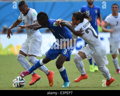 Natal, Brasilien. 24. Juni 2014. Italiens Mario Balotelli (C) wetteifert um den Ball während des Spiels zwischen Italien und Uruguay der FIFA WM 2014 an der Estadio Das Dunas Stadion in Natal, Brasilien, Gruppe D 24. Juni 2014. © Guo Yong/Xinhua/Alamy Live-Nachrichten Stockfoto