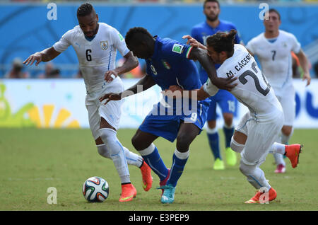 Natal, Brasilien. 24. Juni 2014. Italiens Mario Balotelli (C) wetteifert um den Ball während des Spiels zwischen Italien und Uruguay der FIFA WM 2014 an der Estadio Das Dunas Stadion in Natal, Brasilien, Gruppe D 24. Juni 2014. © Guo Yong/Xinhua/Alamy Live-Nachrichten Stockfoto