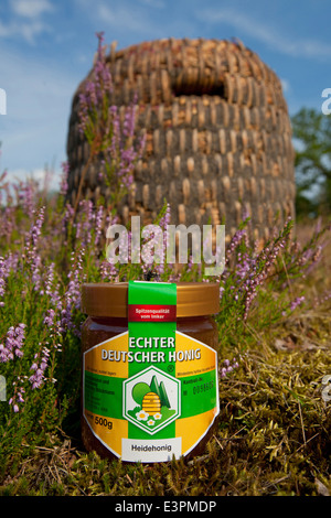 Traditionelle Bienenstöcke (Skeps) aus Stroh mit einem Glas Honig hergestellt. Lüneburger Heide, Niedersachsen, Deutschland Stockfoto