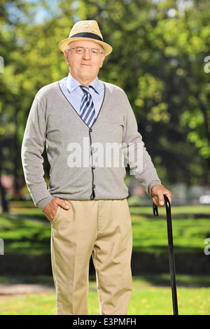 Unbeschwerte senior Gentleman mit einem Stock posiert im freien Stockfoto