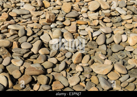 STRAND-STEINEN GEWASCHEN GLATT DURCH WELLE TÄTIGKEIT IN JAHREN Stockfoto