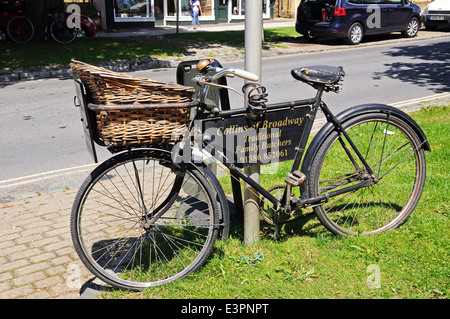 Alten Metzger-Fahrrad mit einem geflochtenen sonnte sich, stützte sich auf einen Laternenpfahl entlang High Street, Broadway, England, UK. Stockfoto