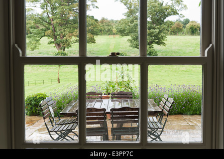 Verglaste Fenster, Blick zum Garten-Terrasse mit Gartenmöbel nass Stockfoto